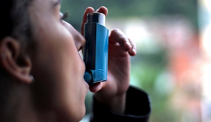 A Woman Using Asthma Kit.