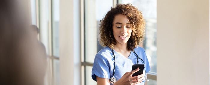 A doctor is having a smartphone in her hand and seeing something in it.